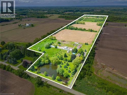 Expansive property featuring a pond, established trees, cleared land, and agricultural fields - 875 Safari Road, Hamilton, ON 