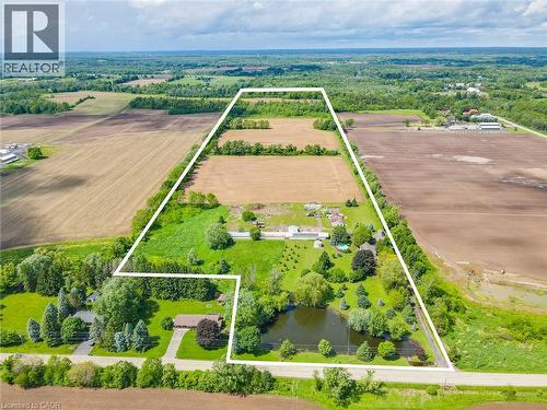 Expansive property featuring a private pond, mature trees, open fields, and distinct boundary lines - 875 Safari Road, Hamilton, ON 