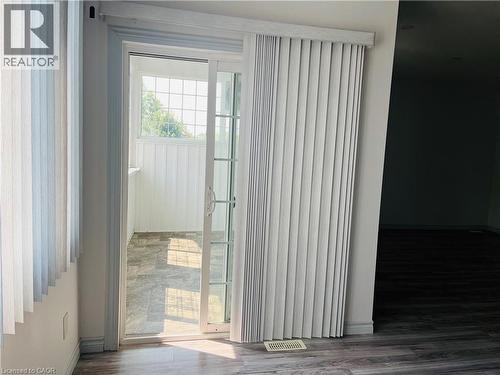Sliding glass patio door with vertical blinds - 83 Keewatin Avenue, Kitchener, ON - Indoor Photo Showing Other Room