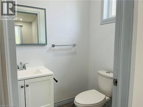 White vanity with integrated sink, chrome faucet, framed mirror, and window with trim - 83 Keewatin Avenue, Kitchener, ON - Indoor Photo Showing Bathroom