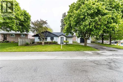 Single-story residence with a paved driveway, detached garage, and mature trees - 15 Spiers Crescent, Cambridge, ON - Outdoor