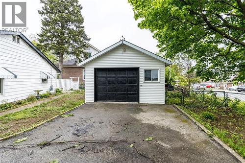 Detached garage with white horizontal siding, a black garage door, and a single window - 15 Spiers Crescent, Cambridge, ON - Outdoor