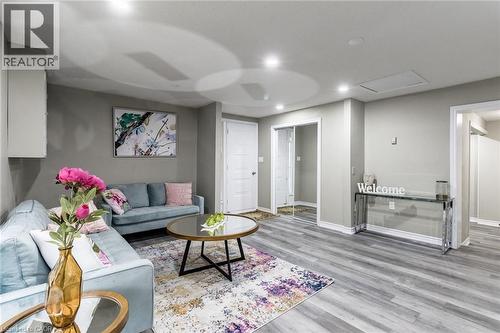 Recessed lighting illuminates the wood-finish flooring in this living space with a white paneled door - 15 Spiers Crescent, Cambridge, ON - Indoor