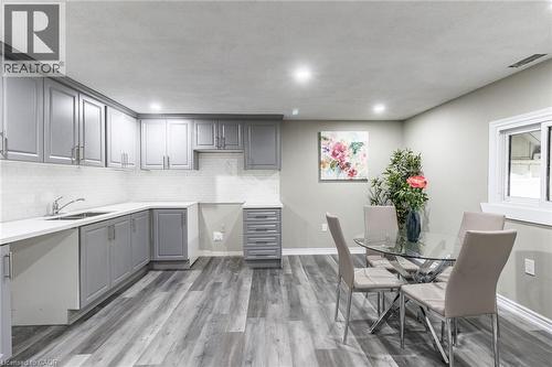 Grey shaker-style cabinetry, white subway tile backsplash, white countertops, wood-finish flooring, and recessed lighting - 15 Spiers Crescent, Cambridge, ON - Indoor