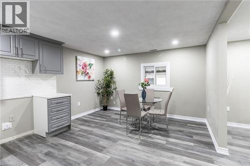 Grey shaker cabinetry, white subway tile backsplash, wood-finish flooring, recessed lighting, and a white-framed window - 15 Spiers Crescent, Cambridge, ON - Indoor