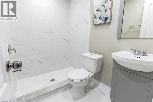 Walk-in shower with large format wall tiles, mosaic tile shower floor, modern toilet, and a vanity with an integrated sink - 15 Spiers Crescent, Cambridge, ON - Indoor Photo Showing Bathroom