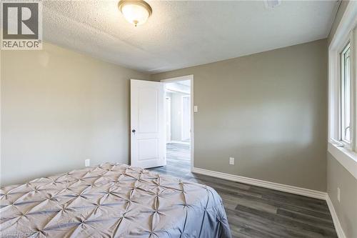 Neutral wall paint, wood-finish flooring, white trim, and a ceiling-mounted light fixture - 15 Spiers Crescent, Cambridge, ON - Indoor Photo Showing Bedroom