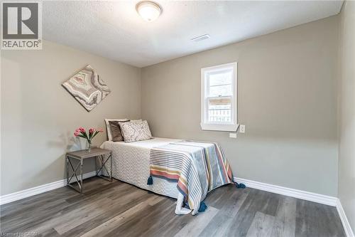 Wood-finish flooring, neutral wall paint, white trim, and a double-hung window - 15 Spiers Crescent, Cambridge, ON - Indoor Photo Showing Bedroom