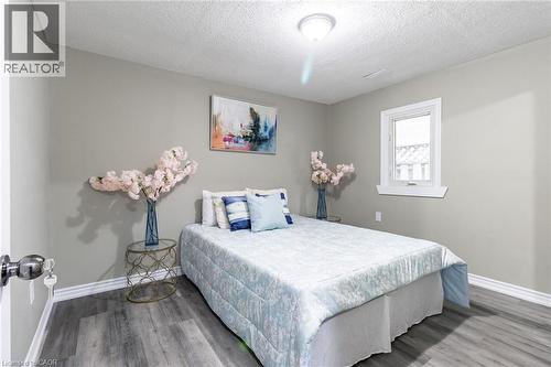 Light-toned walls, wood-finish flooring, white window trim, and a ceiling-mounted light fixture - 15 Spiers Crescent, Cambridge, ON - Indoor Photo Showing Bedroom