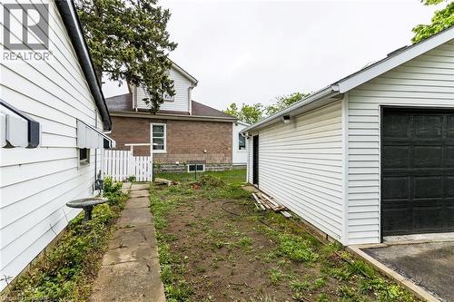 Detached garage with white siding and dark garage door - 15 Spiers Crescent, Cambridge, ON - Outdoor With Exterior