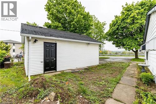Detached garage with white siding, black paneled door, and security lighting - 15 Spiers Crescent, Cambridge, ON - Outdoor
