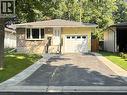 Exterior featuring a stone veneer facade, yellow siding, and a white garage door - 510 Oakridge Place, Waterloo, ON  - Outdoor 