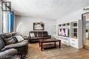 Wood-finish flooring throughout, recessed ceiling detail, and a built-in media center with shelving - 510 Oakridge Place, Waterloo, ON  - Indoor Photo Showing Living Room 