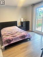 Wood-finish flooring, sliding glass door, private deck, and a contemporary dark wood-finish dresser - 