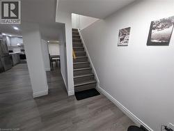 Wood-finish flooring throughout, with a neutral wall color and recessed lighting - 
