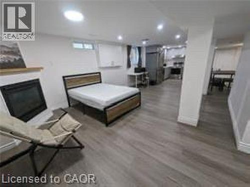 Wood-finish flooring throughout, fireplace with a wood mantle, recessed lighting, and kitchen area with stainless steel appliances - 510 Oakridge Place, Waterloo, ON - Indoor