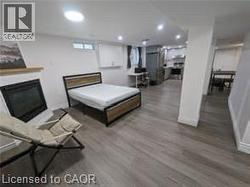 Wood-finish flooring throughout, fireplace with a wood mantle, recessed lighting, and kitchen area with stainless steel appliances - 