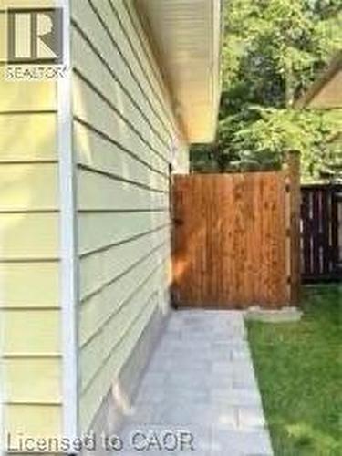 Siding exterior, paved walkway, wooden fence, and manicured lawn - 510 Oakridge Place, Waterloo, ON - Outdoor