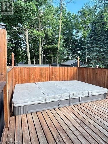 Expansive deck featuring a hot tub, wood privacy fencing, and mature trees - 510 Oakridge Place, Waterloo, ON - Outdoor With Deck Patio Veranda