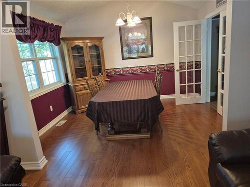 Hardwood-finish flooring, vaulted ceiling, white-framed window, and white French doors - 599 Coldstream Drive, Waterloo, ON - Indoor Photo Showing Bedroom