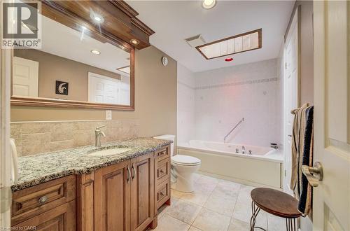 Full bathroom featuring a single vanity with stone countertop, undermount sink, and wood cabinetry - 599 Coldstream Drive, Waterloo, ON - Indoor Photo Showing Bathroom