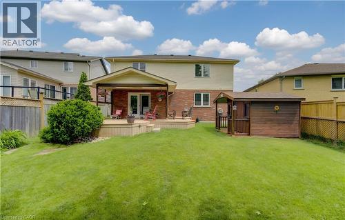 Expansive green lawn with a multi-level wood deck featuring a covered patio - 599 Coldstream Drive, Waterloo, ON - Outdoor With Deck Patio Veranda