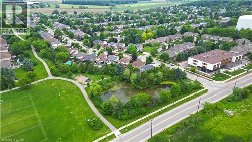 Aerial perspective showcasing a residential neighborhood with a variety of housing styles, established tree cover, and community amenities - 599 Coldstream Drive, Waterloo, ON - Outdoor With View
