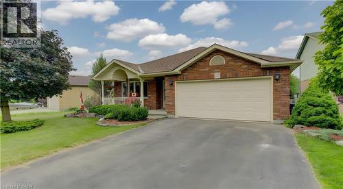 Brick exterior featuring an attached two-car garage with a light-toned door - 599 Coldstream Drive, Waterloo, ON - Outdoor With Facade
