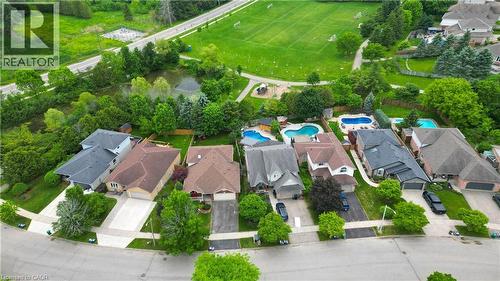 Aerial perspective showcasing a residential street with diverse home exteriors, private driveways, and expansive green spaces - 599 Coldstream Drive, Waterloo, ON - Outdoor With View