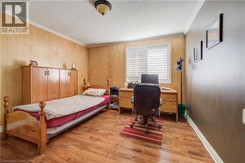 Room featuring wood-finish flooring, white crown molding, and a built-in window with horizontal blinds - 599 Coldstream Drive, Waterloo, ON - Indoor Photo Showing Bedroom