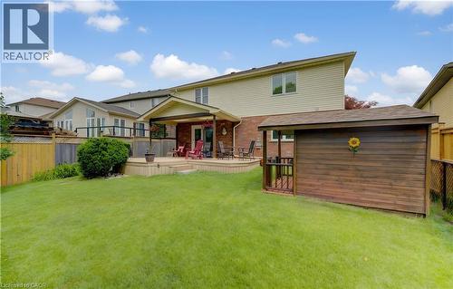 Expansive backyard featuring a lush lawn, multi-level wood deck, covered patio area, and a detached wood-sided shed - 599 Coldstream Drive, Waterloo, ON - Outdoor With Deck Patio Veranda