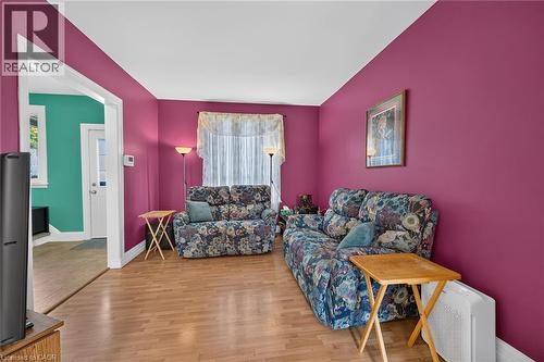 Wood-finish flooring with vibrant wall color and white trim - 230 Picton Street E, Hamilton, ON - Indoor Photo Showing Living Room