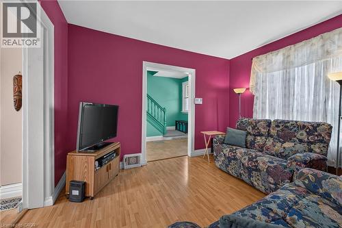 Wood-finish flooring throughout, bright magenta wall color, and white trim - 230 Picton Street E, Hamilton, ON - Indoor