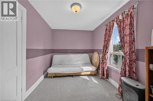 Carpeted room with a double-hung window, light fixture, and painted walls featuring a horizontal band - 230 Picton Street E, Hamilton, ON - Indoor
