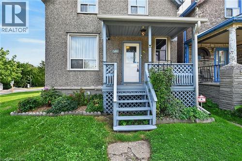 Front porch with wood-finish railing, steps, and latticework - 230 Picton Street E, Hamilton, ON - Outdoor With Deck Patio Veranda