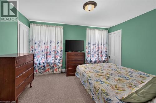 Carpeted room with a flush-mount ceiling light fixture, white trim, and two paneled doors - 230 Picton Street E, Hamilton, ON - Indoor Photo Showing Bedroom