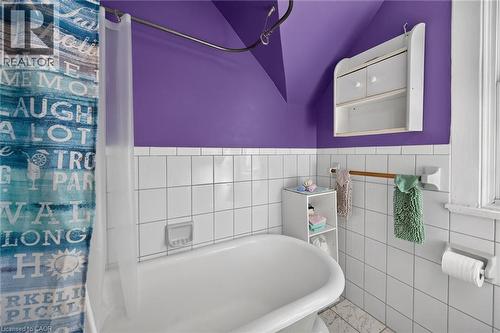 White subway tile surround, built-in wall cabinet, towel bar, and a window - 230 Picton Street E, Hamilton, ON - Indoor Photo Showing Bathroom