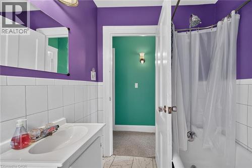 White tiled wainscoting and a wall-mounted mirror - 230 Picton Street E, Hamilton, ON - Indoor Photo Showing Bathroom