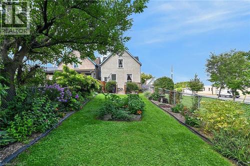 Expansive backyard featuring a manicured lawn, established garden beds, and mature trees - 230 Picton Street E, Hamilton, ON - Outdoor