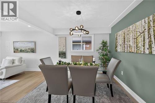 Recessed lighting, wood-finish flooring, accent wall, modern light fixture, white trim - 40 Purdy Crescent, Hamilton, ON - Indoor Photo Showing Dining Room