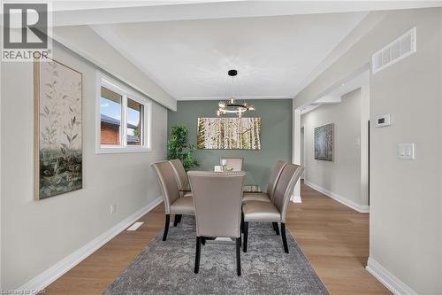 Hardwood-style flooring, contemporary chandelier, recessed ceiling beams, and a window with white trim - 40 Purdy Crescent, Hamilton, ON - Indoor Photo Showing Dining Room