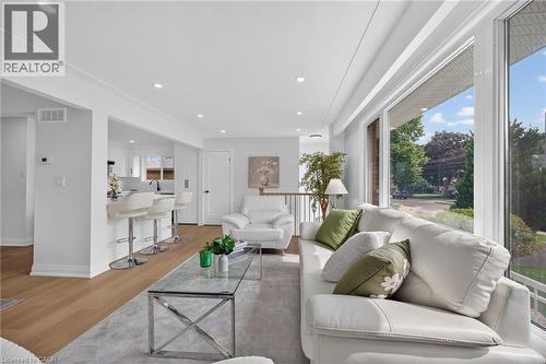 Expansive floor-to-ceiling windows, wood-finish flooring, recessed lighting, and crown molding - 40 Purdy Crescent, Hamilton, ON - Indoor Photo Showing Living Room