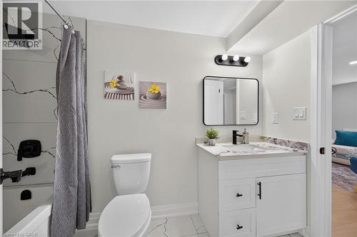 Bathroom featuring a white vanity with dark hardware, a rectangular undermount sink, and a stone-finish countertop - 40 Purdy Crescent, Hamilton, ON - Indoor Photo Showing Bathroom