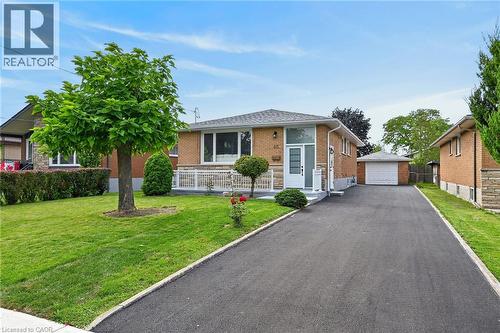 Brick exterior, attached front porch, paved driveway, detached garage, and mature landscaping - 40 Purdy Crescent, Hamilton, ON - Outdoor With Facade