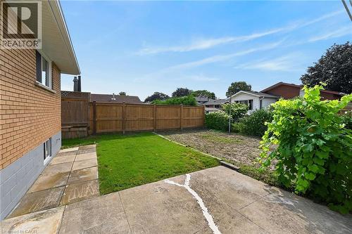 Brick exterior with a partial concrete block foundation, a fenced perimeter, and a grassed area - 40 Purdy Crescent, Hamilton, ON - Outdoor