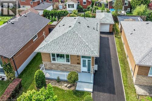 Brick exterior with stone accents, covered front porch, asphalt driveway, and detached garage - 40 Purdy Crescent, Hamilton, ON - Outdoor