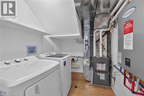 Dedicated utility space with durable wood-finish flooring - 40 Purdy Crescent, Hamilton, ON - Indoor Photo Showing Laundry Room