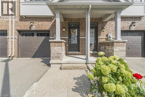 Brick exterior with stone accents, covered entry, and integrated single-car garage - 1890 Rymal Road E Unit# 144, Hamilton, ON - Outdoor