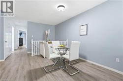 Wood-finish flooring throughout, light blue wall paint, white trim, and a contemporary ceiling light fixture - 