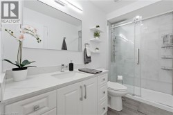 White vanity with a single basin, stainless steel faucet, and quartz countertop - 